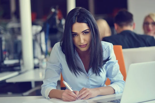 Image d'une femme utilisant un ordinateur portable assis à son bureau . — Photo