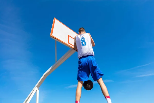 Joven jugador callejero de baloncesto haciendo slam dunk — Foto de Stock