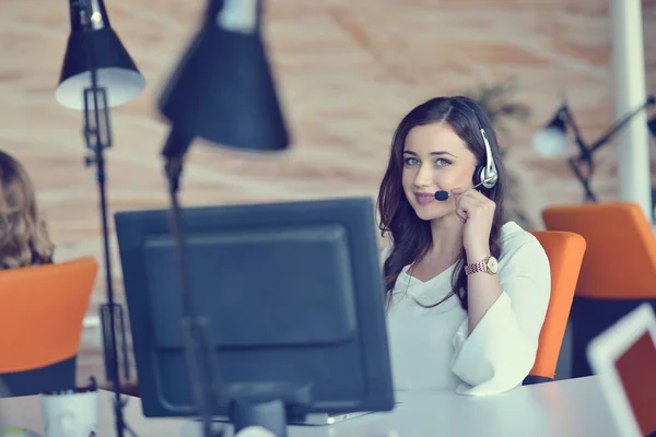 Attractive woman listening to music while working in startup business office — Stock Photo, Image