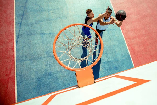 Vista de alto ângulo do jogador de basquete mascando basquete em aro — Fotografia de Stock