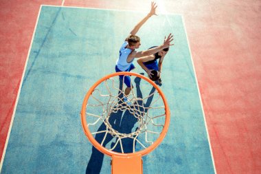 Basketbolcunun basketbolu potada smaç basmasının yüksek açılı görüntüsü