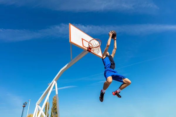 Jeune joueur de rue de basket-ball faisant slam dunk — Photo