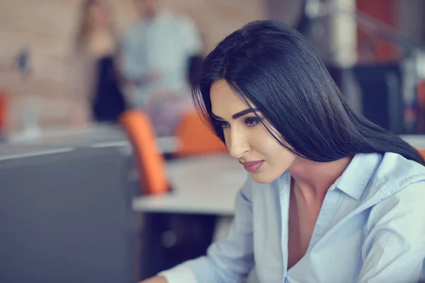 Image d'une femme utilisant un ordinateur portable assis à son bureau . — Photo