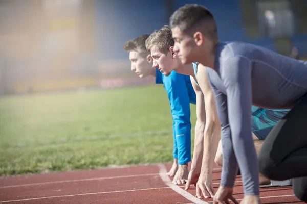 Athletes at the sprint start line in track and field — Stock Photo, Image