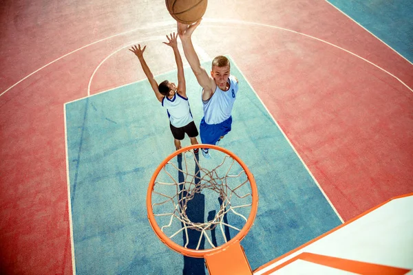 농구 선수가 엉덩이에 농구공을 박는 모습 — 스톡 사진