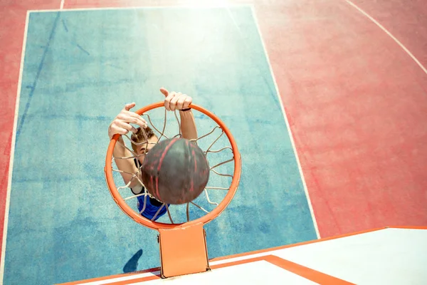 Jeune homme sautant et faisant un dunk slam fantastique jouer au streetball, basket-ball. Urbain authentique. — Photo