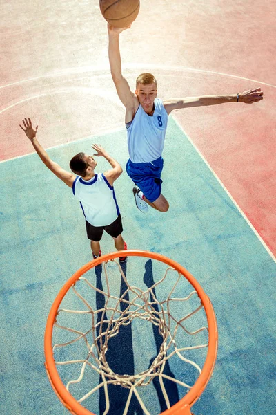 Vista de alto ângulo do jogador de basquete mascando basquete em aro — Fotografia de Stock