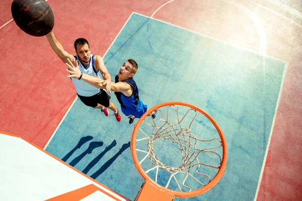 Hoge hoek uitzicht van basketbalspeler dunking basketbal in hoepel — Stockfoto