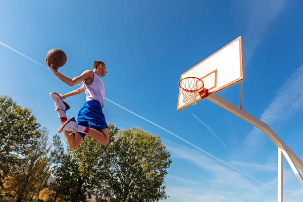 Jeune joueur de rue de basket-ball faisant slam dunk — Photo