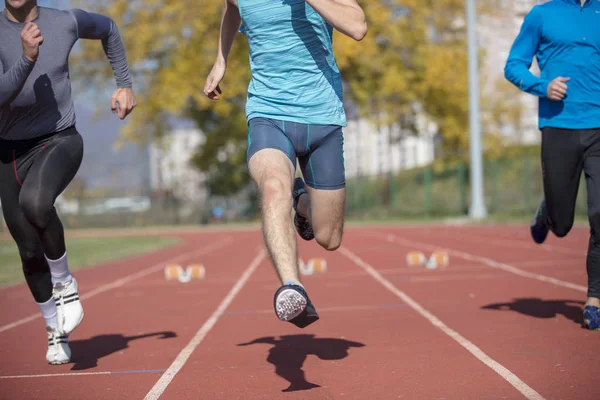 Atletas en la línea de salida del sprint en pista y campo — Foto de Stock