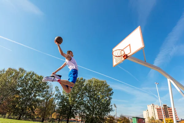 Молодий вулиці баскетболіст робить slam dunk — стокове фото