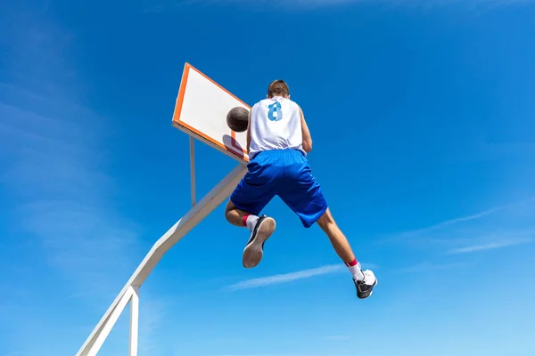 Молодий вулиці баскетболіст робить slam dunk — стокове фото