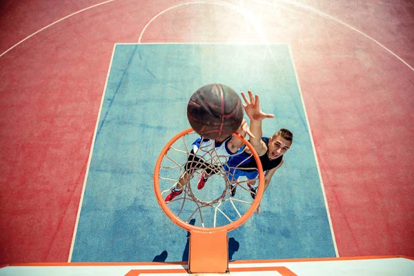 Vista de alto ângulo do jogador de basquete mascando basquete em aro — Fotografia de Stock