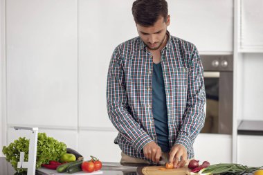 Evdeki mutfakta birlikte yemek pişiren mutlu genç çiftin portresi..