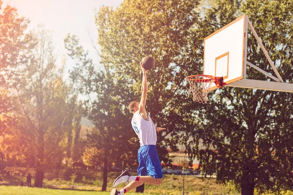 Jugador de baloncesto callejero realizando power slum dunk —  Fotos de Stock