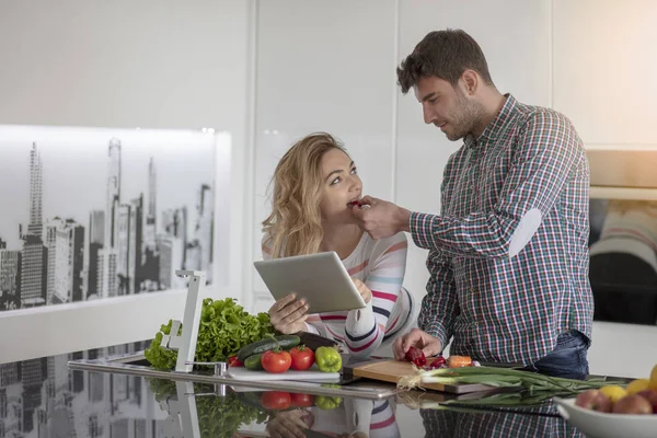 Retrato de pareja joven y feliz cocinando juntos en la cocina en casa. — Foto de Stock