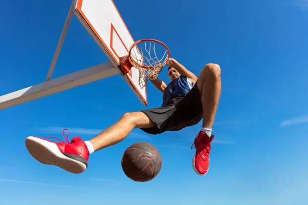 Slam Dunk. Vista lateral do jogador de basquete jovem fazendo slam dunk — Fotografia de Stock