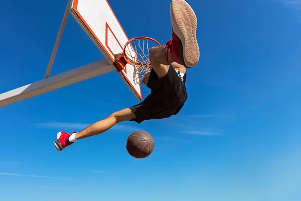 Slam Dunk. Vista lateral del joven jugador de baloncesto haciendo slam dunk — Foto de Stock