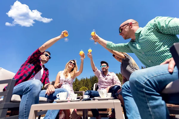 Grupp vänner rosta deras juice glas nära pool — Stockfoto