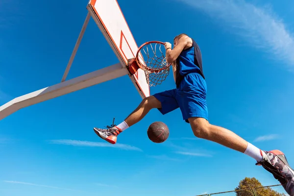 Slam Dunk. Vista lateral do jogador de basquete jovem fazendo slam dunk — Fotografia de Stock