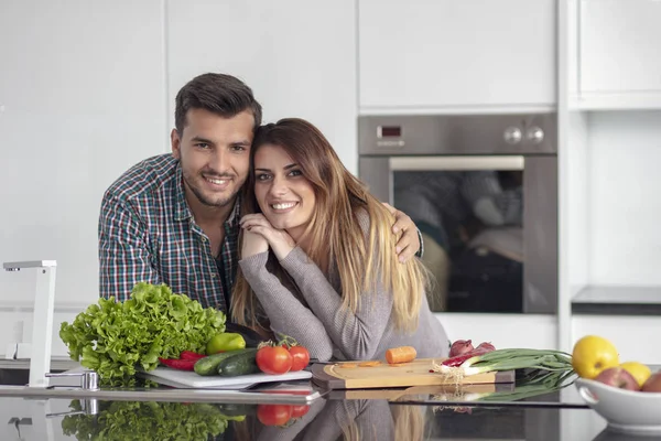 Portrait de jeune couple heureux cuisiner ensemble dans la cuisine à la maison. — Photo