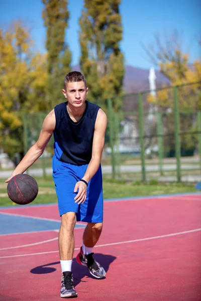 Yakışıklı erkek dışarıda basketbol oynuyor. — Stok fotoğraf