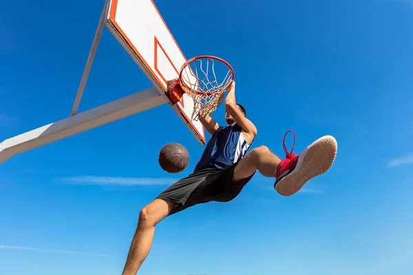 Slam-Dunk. Seitenansicht eines jungen Basketballspielers, der Slam Dunk macht — Stockfoto