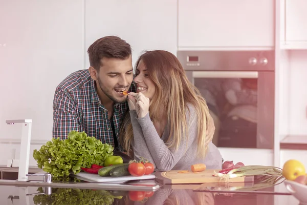 Retrato de casal jovem feliz cozinhar juntos na cozinha em casa. — Fotografia de Stock