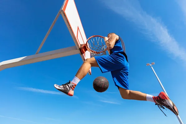 Slam Dunk. Вид сбоку на молодого баскетболиста, делающего слэм-данк — стоковое фото