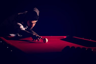 Bir sakallı bir adam büyük bir bilardo oynuyor.