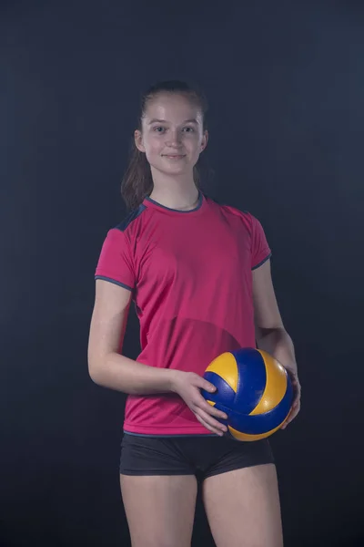 Junge Volleyballerin isoliert auf dunklem Hintergrund — Stockfoto