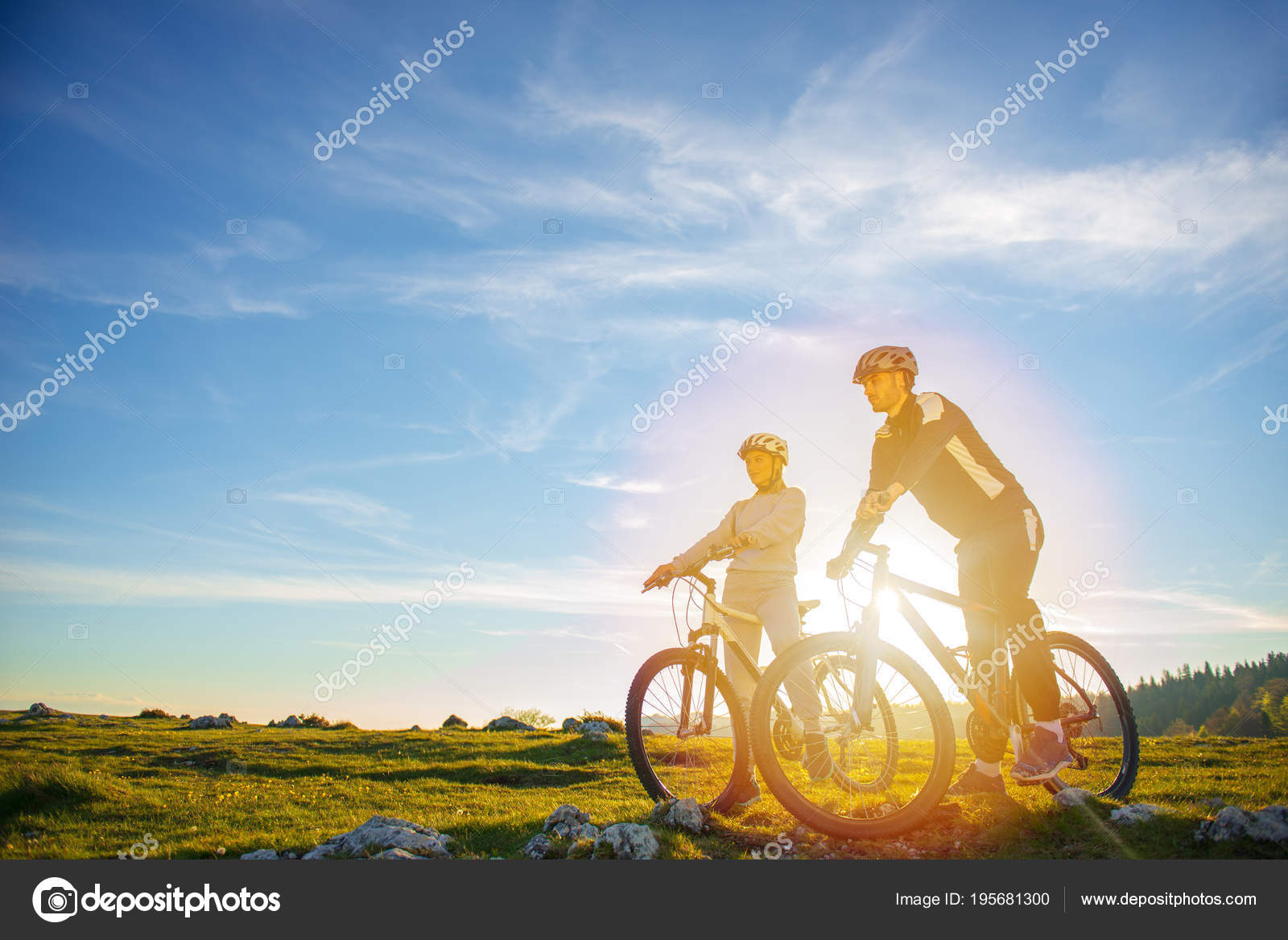 Pareja ciclista con bicicletas de montaña de pie en la colina bajo