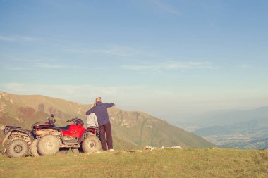 Atv yakınındaki genç çiftinin arka görüş. Adam bir şeyler kız arkadaşı uzaklığını gösteriyor.