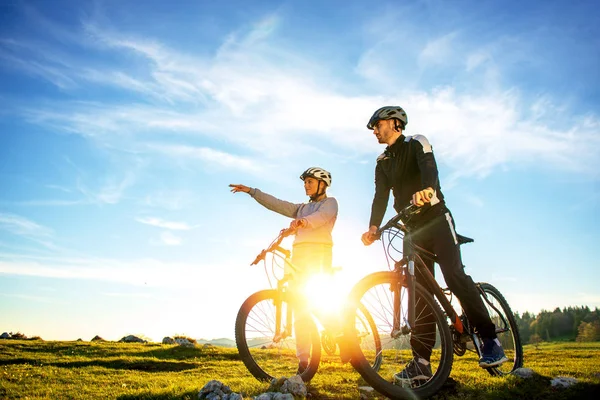 Motorcu çift kırsal gün ışığında işaret dağ bisikleti ile — Stok fotoğraf