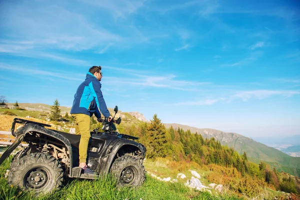 Homem na quadriciclo ATV na estrada das montanhas . — Fotografia de Stock