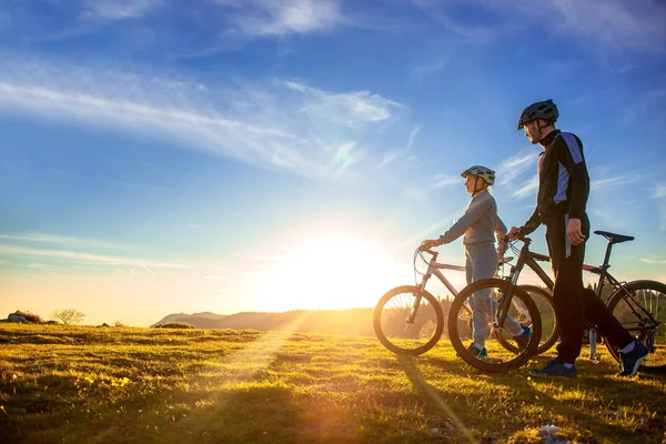 Mountainbike ευτυχισμένο ζευγάρι σε εξωτερικούς χώρους να διασκεδάσουμε όλοι μαζί σε ένα καλοκαίρι απογευματινό ηλιοβασίλεμα — Φωτογραφία Αρχείου