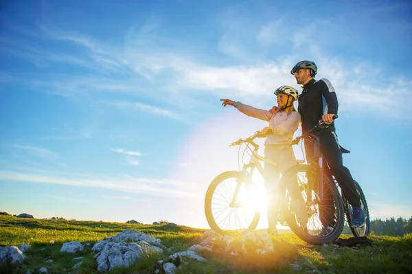 Motorcu çift kırsal gün ışığında işaret dağ bisikleti ile — Stok fotoğraf