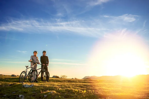 Feliz mountain bike pareja al aire libre divertirse juntos en un verano por la tarde puesta de sol —  Fotos de Stock