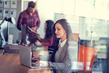 Ofiste grafik tabletle çalışan yaratıcı genç kadın.