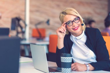 Müşteri hizmetleri temsilcisi iş başında. Bilgisayar çalışma kulaklık güzel genç kadın