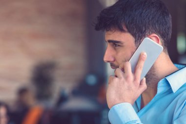 Ofis telefonu: çağrı genç gülümseyen iş adamı.