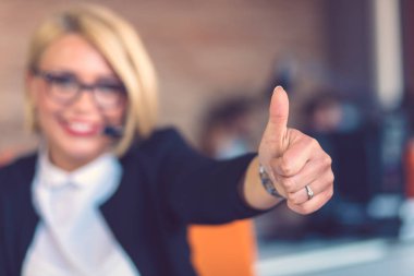 Müşteri hizmetleri temsilcisi iş başında. Bilgisayar çalışma kulaklık güzel genç kadın