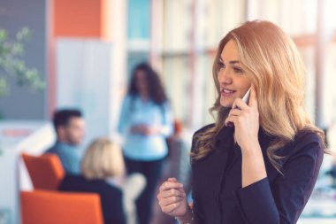Ekibin önünde cep telefonuyla konuşan bir kadın.