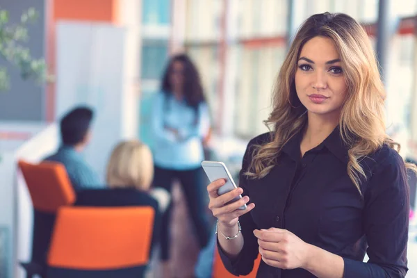 Žena mluví na mobilním telefonu před týmem — Stock fotografie