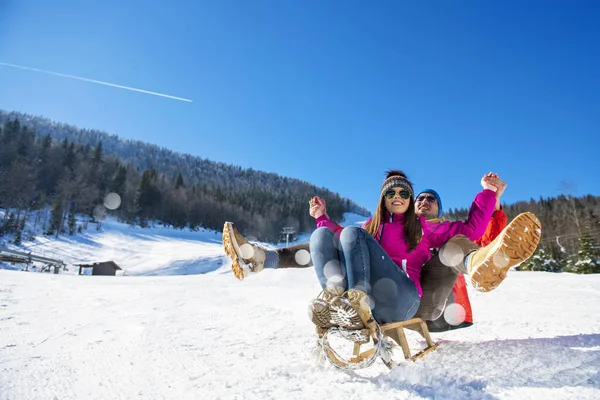 年轻快乐的夫妇在冬季滑雪场滑行 — 图库照片