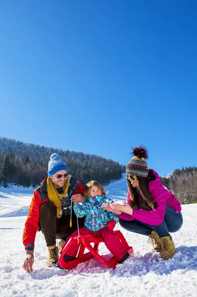 Família feliz na neve equitação no trenó . — Fotografia de Stock