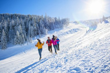 Arkadaşlar kışın taze karda eğlenir.