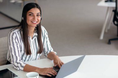 Çağrı merkezinde çalışan mutlu, gülümseyen kadın