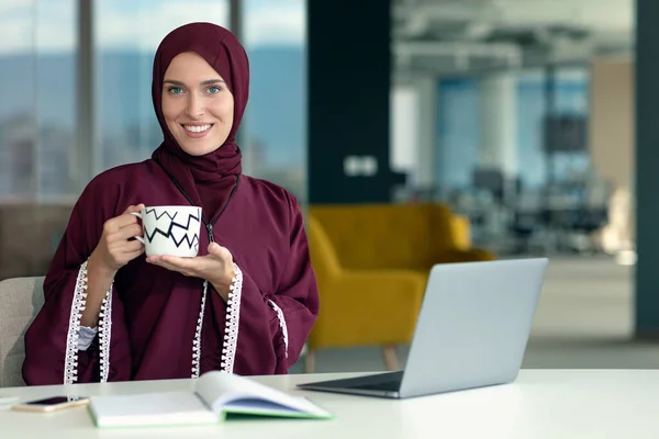 Fiatal, fiatal muszlim üzletasszony, mobil digitális táblagépet használ a munkahelyén — Stock Fotó