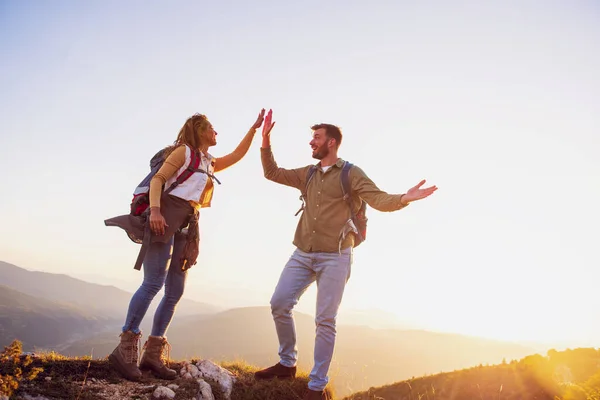 Pareja en la cima de una montaña sacudiendo manos levantadas —  Fotos de Stock